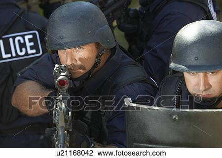 Stock Image - Swat officers with gun and shield. Fotosearch
