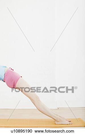 Stock Image - Teenage girl (16-17) exercising low section. Fotosearch