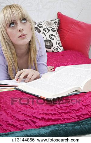 Teenage girl (16-17) lying on bed looking up View Large Photo Image Stock Photograph - Teenage girl (16-17) lying on bed looking up. Fotosearch
