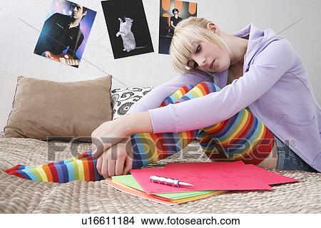 Teenage girl (16-17) sitting on bed View Large Photo Image Picture - Teenage girl (16-17) sitting on bed. Fotosearch