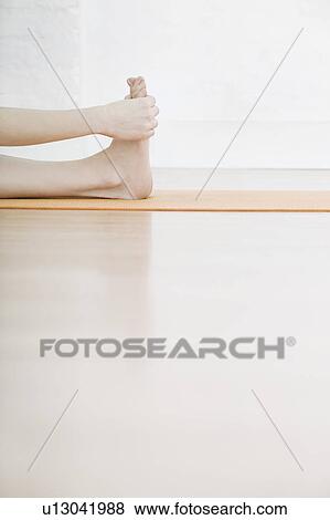 Stock Photo - Teenage girl (16-17) stretching leg low section. Fotosearch