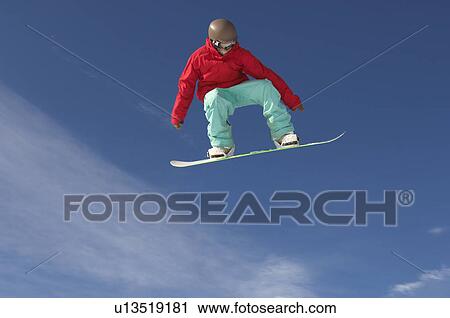 Stock Image - Teenage snowboarder jumping. Fotosearch