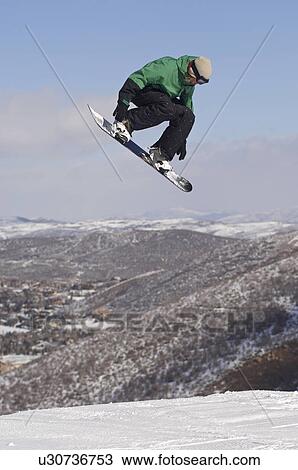 Stock Image - Teenage snowboarder jumping. Fotosearch
