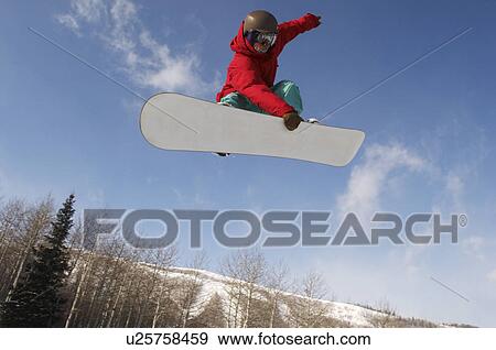 Stock Photo - Teenage snowboarder jumping. Fotosearch