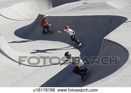 Three teenage boys (16-17) skateboarding at skate park elevated view View Large Photo Image Stock Photo - Three teenage boys (16-17) skateboarding at skate park elevated view. Fotosearch