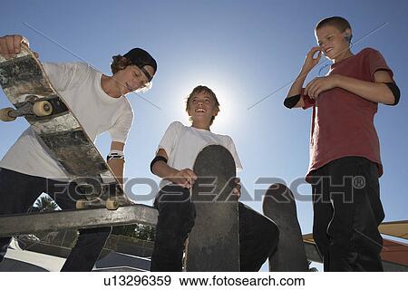 Three teenage boys (16-17) with skateboards outdoors View Large Photo Image Stock Photo - Three teenage boys (16-17) with skateboards outdoors. Fotosearch