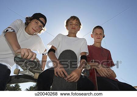 Three teenage boys (16-17) with skateboards outdoors portrait View Large Photo Image Stock Photo - Three teenage boys (16-17) with skateboards outdoors portrait. Fotosearch