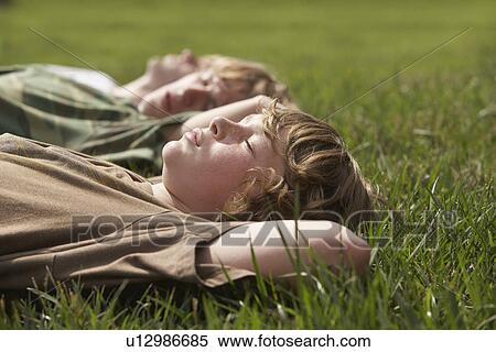 Three teenage brothers (13-17) lying down on grass close up View Large Photo Image Stock Photography - Three teenage brothers (13-17) lying down on grass close up. Fotosearch