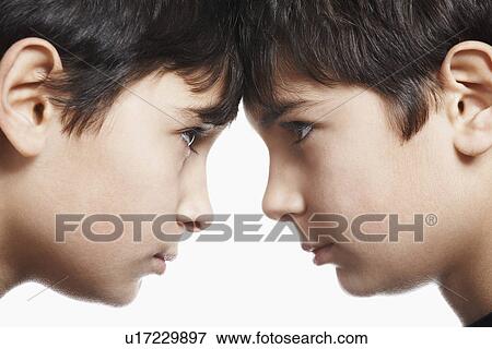 Stock Photo - Twin boys (13-15) head to head close-up. Fotosearch