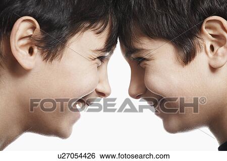 Stock Photograph - Twin boys (13-15) head to head laughing close-up. Fotosearch