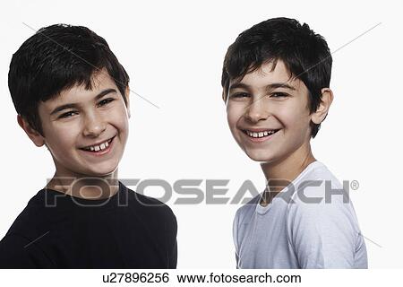 Stock Photograph - Twin boys (13-15) smiling portrait. Fotosearch