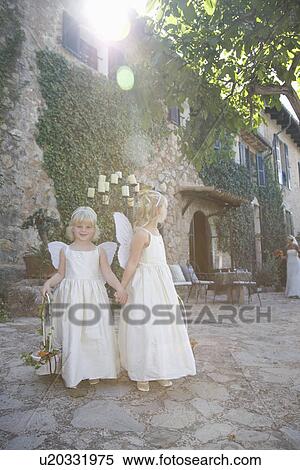 Stock Photography - Two girls wearing wings outdoors. Fotosearch