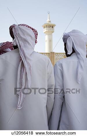 UAE Dubai group of traditionally dressed Muslim men perform a song for visitors to the Bastakia View Large Photo Image Stock Photo - UAE Dubai group of traditionally dressed Muslim men perform a song for visitors to the Bastakia. Fotosearch