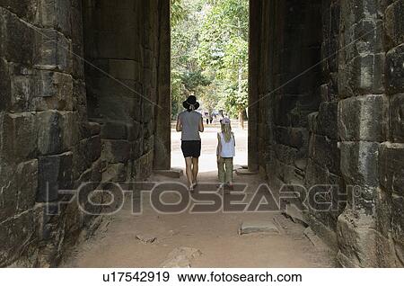 Stock Photo - Woman and Girl Walking Through Passage in Ancient Building. Fotosearch