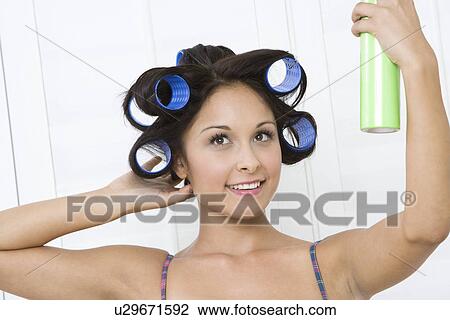 Stock Image - Woman applying hair spray. Fotosearch