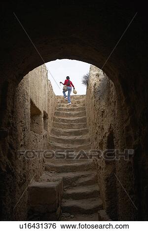 Stock Photograph - Woman Climbing Stairs in the Tombs of the Kings Paphos Cyprus. Fotosearch