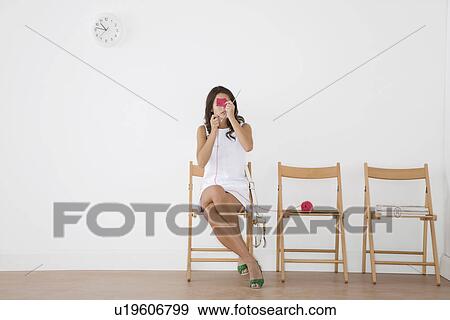 Stock Photo - Woman knitting in a waiting room. Fotosearch