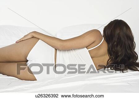 Woman lying on bed View Large Photo Image Stock Image - Woman lying on bed. Fotosearch