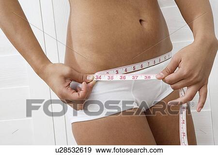 Woman measuring waist View Large Photo Image Stock Photo - Woman measuring waist. Fotosearch