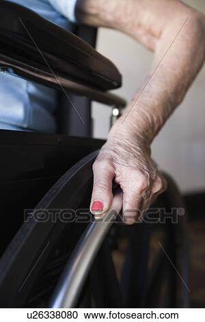 Stock Image - Woman operating wheelchair. Fotosearch
