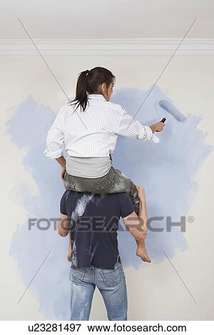 Woman riding shoulders of man to paint wall View Large Photo Image Stock Photo - Woman riding shoulders of man to paint wall. Fotosearch