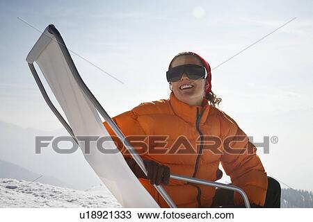 Woman sitting in lawn chair in snow View Large Photo Image Stock Image - Woman sitting in lawn chair in snow. Fotosearch