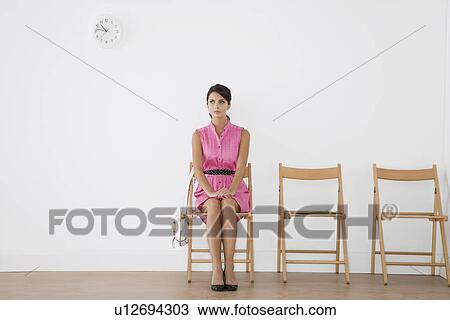 Stock Image - Woman sitting in waiting room. Fotosearch