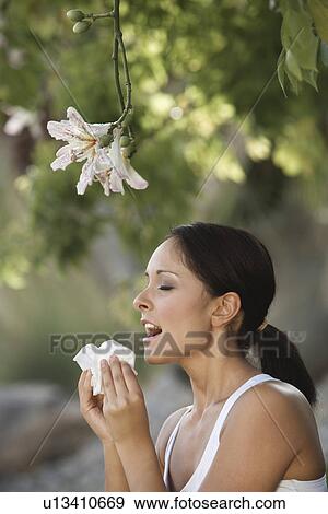 Woman sneezing under tree View Large Photo Image Stock Photo - Woman sneezing under tree. Fotosearch