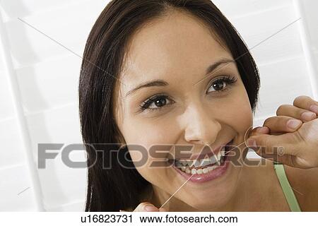 Stock Image - Woman using dental floss. Fotosearch