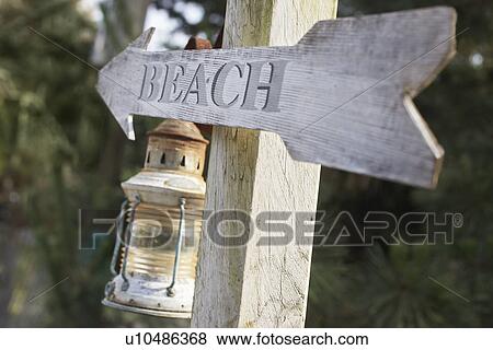 Wooden post with lantern and arrow reading 'beach' View Large Photo Image Stock Photo - Wooden post with lantern and arrow reading 'beach'. Fotosearch