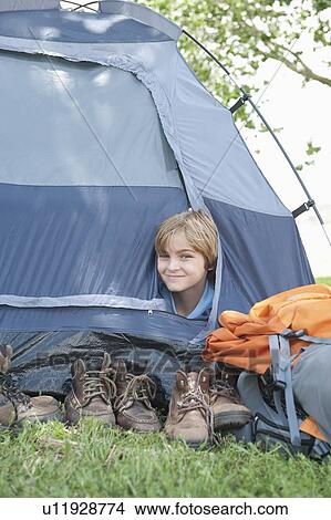 Picture - Young boy peaks out of tent. Fotosearch