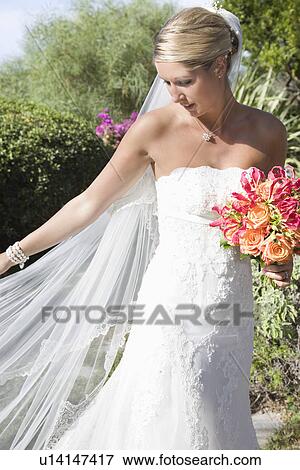 Stock Photo - Young bride holding bouquet. Fotosearch