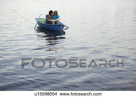 Picture - Young Couple Cuddling in Rowboat on Lake. Fotosearch