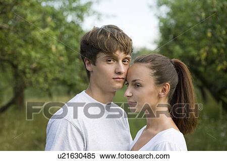 Stock Photography - Young couple embracing in orchard. Fotosearch