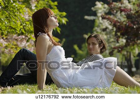 Young Couple Sitting in the Grass View Large Photo Image Stock Image - Young Couple Sitting in the Grass. Fotosearch
