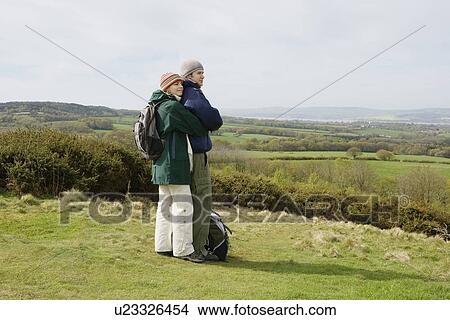 Young Couple Standing in a Field View Large Photo Image Picture - Young Couple Standing in a Field. Fotosearch