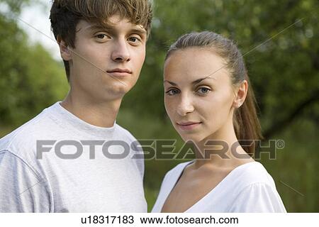 Young couple standing side to side in orchard View Large Photo Image Stock Image - Young couple standing side to side in orchard. Fotosearch