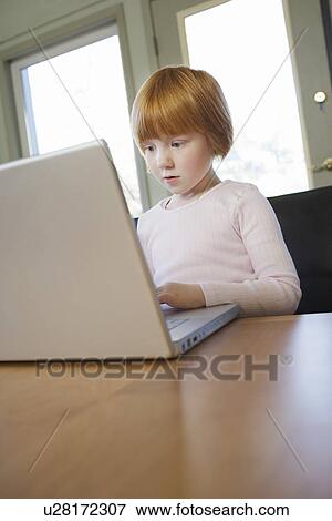 Young girl (5-6) using laptop concentrated View Large Photo Image Stock Photo - Young girl (5-6) using laptop concentrated. Fotosearch