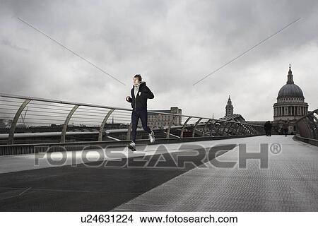 Young male runner on the Millenium Bridge with St Paul's in the background View Large Photo Image Picture - Young male runner on the Millenium Bridge with St Paul's in the background. Fotosearch