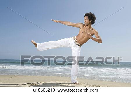 Young man exercising on beach View Large Photo Image Stock Image - Young man exercising on beach. Fotosearch