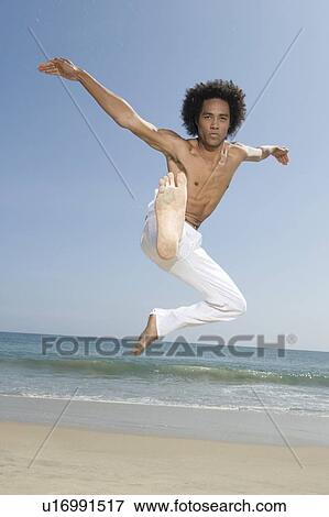 Young man exercising on beach View Large Photo Image Stock Photo - Young man exercising on beach. Fotosearch