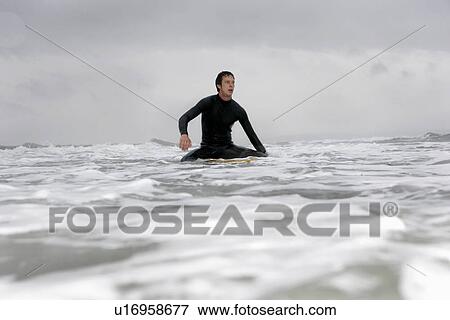 Young man on surfboard in ocean View Large Photo Image Stock Photo - Young man on surfboard in ocean. Fotosearch