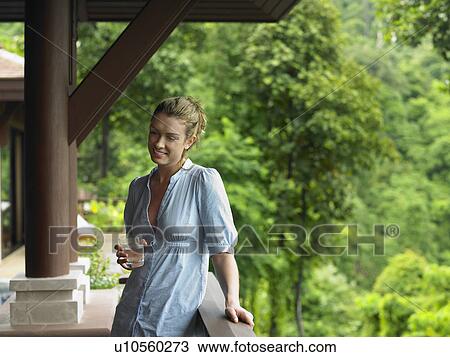 Young Woman Beneath Veranda with Glass of Water View Large Photo Image Stock Image - Young Woman Beneath Veranda with Glass of Water. Fotosearch