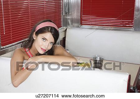 Picture - Young Woman in a Diner Booth. Fotosearch