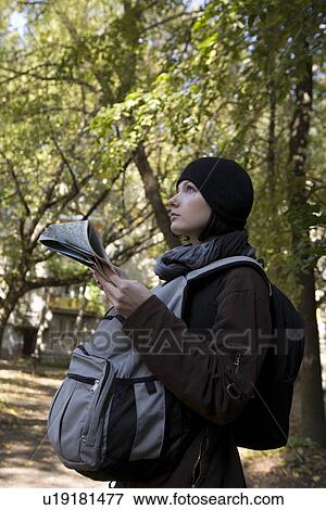 Stock Photo - Young woman in winter clothes reading map. Fotosearch