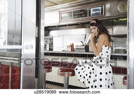 Young Woman Sitting in a Diner Drinking a Shake View Large Photo Image Stock Photo - Young Woman Sitting in a Diner Drinking a Shake. Fotosearch