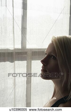 Young woman standing by window close-up View Large Photo Image Stock Photography - Young woman standing by window close-up. Fotosearch