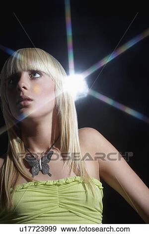 Stock Photo - Young woman standing in disco. Fotosearch