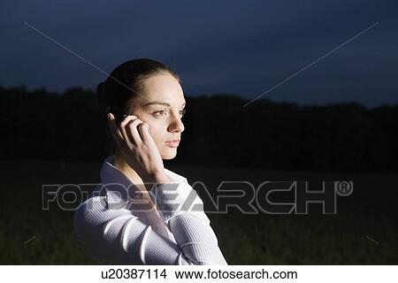Young woman using mobile phone in field View Large Photo Image Picture - Young woman using mobile phone in field. Fotosearch