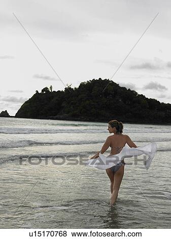 Stock Photo - Young Woman Wading in Ocean. Fotosearch